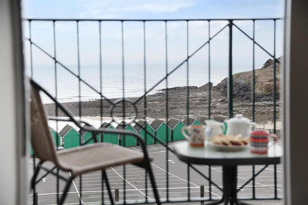 a table and chairs on a balcony with a view of the ocean at 1 Bed in Langland oc-hh147 in Newton