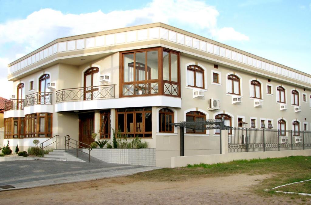 a large white building with large windows at Hotel Recanto do Imperador in Rio Pardo