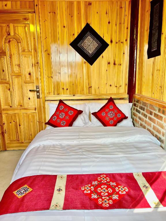 a bedroom with a bed with red pillows on it at H'mong Village Homestay in Sapa