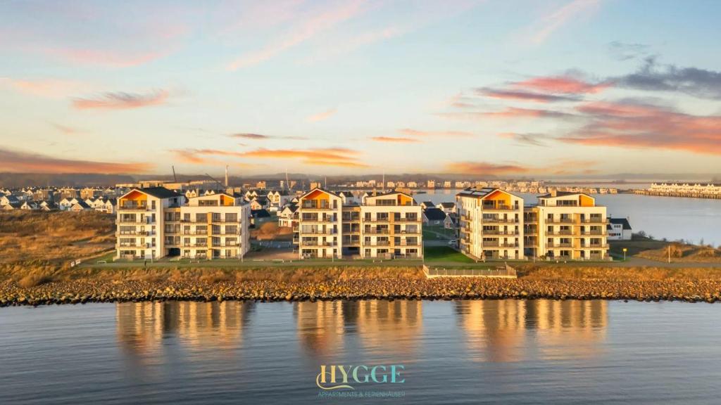 a group of apartment buildings next to a body of water at Penthouse Hygge Meerblick - Olpenitz in Olpenitzdorf