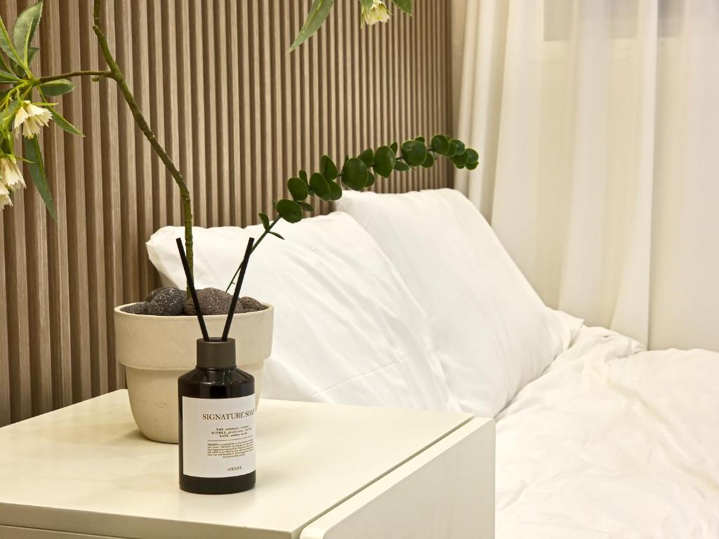a bottle of wine on a table with a potted plant at Gwanganli Breeze Bay in Kwangan-dong