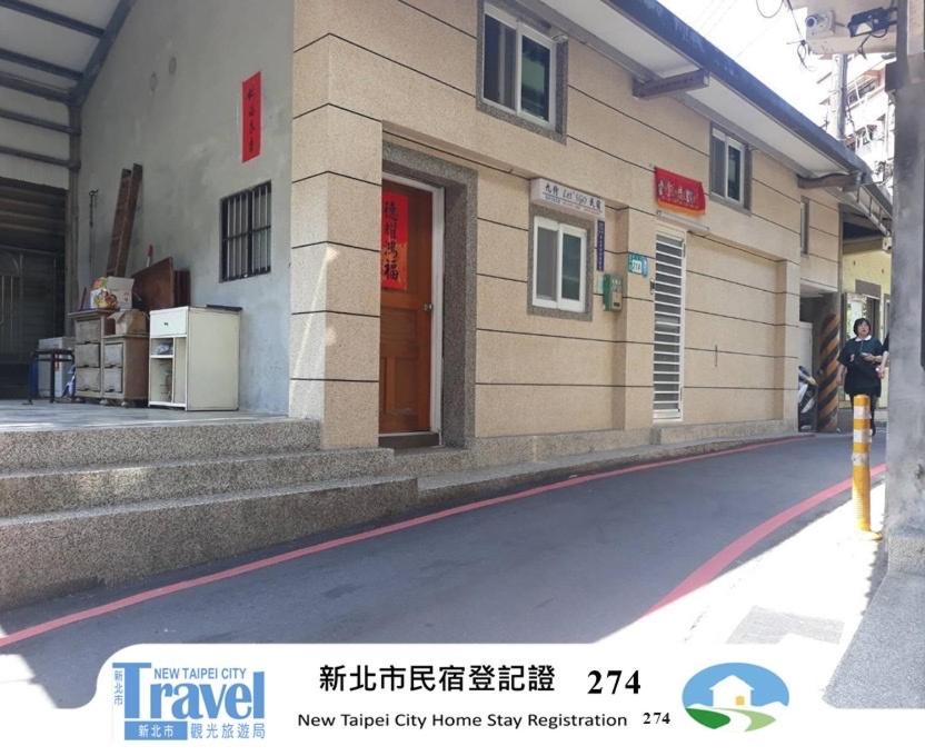a building with a person standing outside of it at Jiufen Let's go Bed and Breakfast in Jiufen