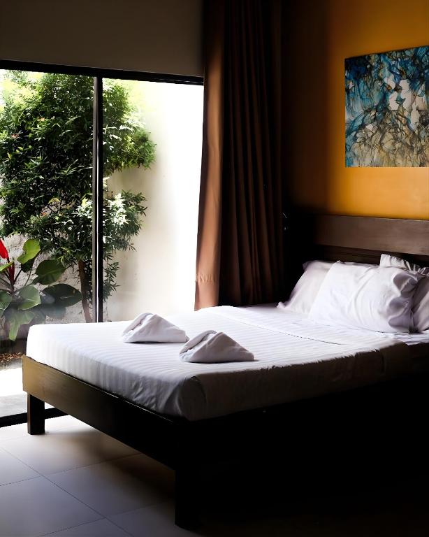 a bed in a bedroom with a large window at Cresebo Mansion in Tagbilaran City