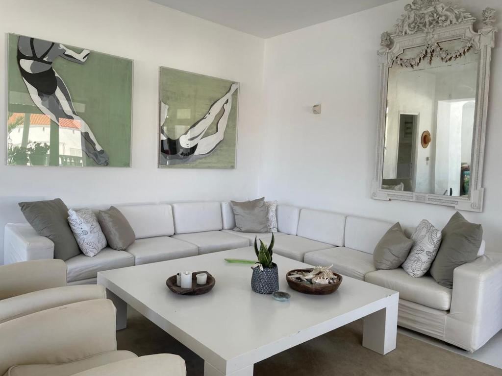 a living room with a white couch and a table at The White House 1 in Andros