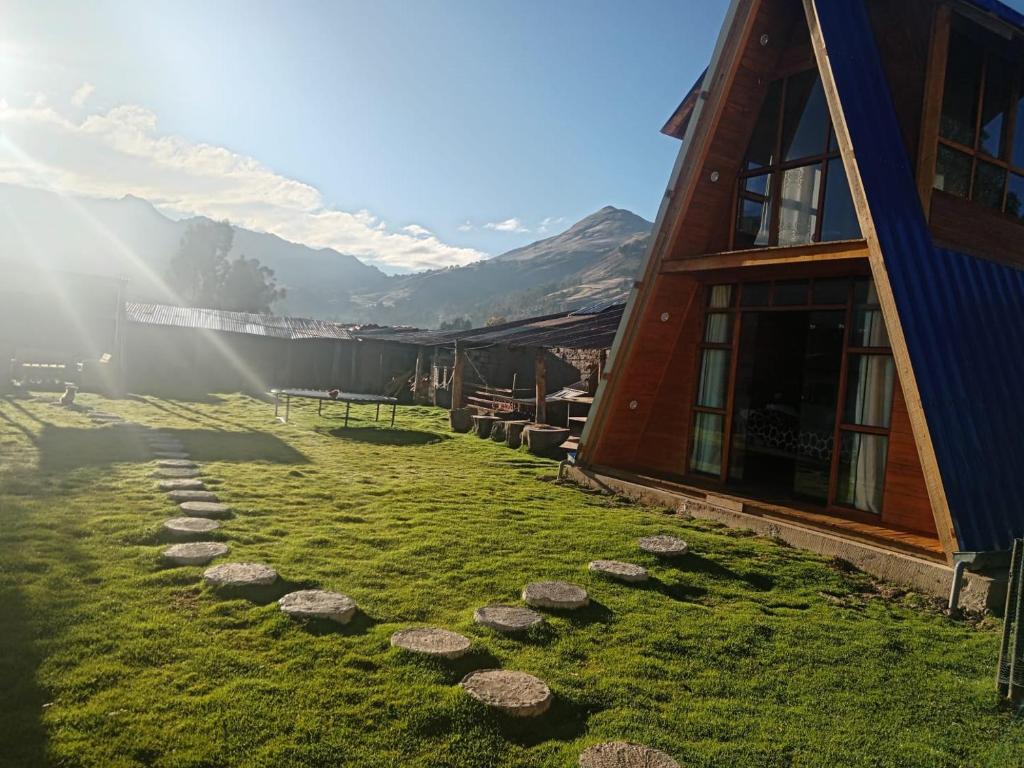 a grassy yard next to a building with rocks at Casa de campo y Chalet las Morenas in Sicuani