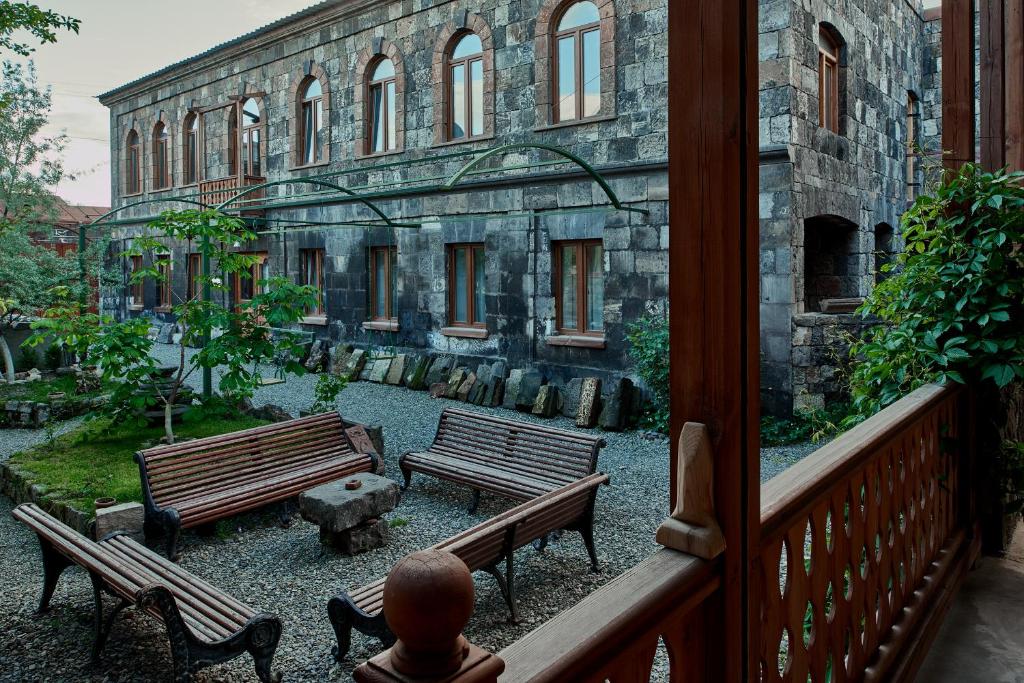 a balcony with two benches in front of a building at Villa Kars in Gyumri