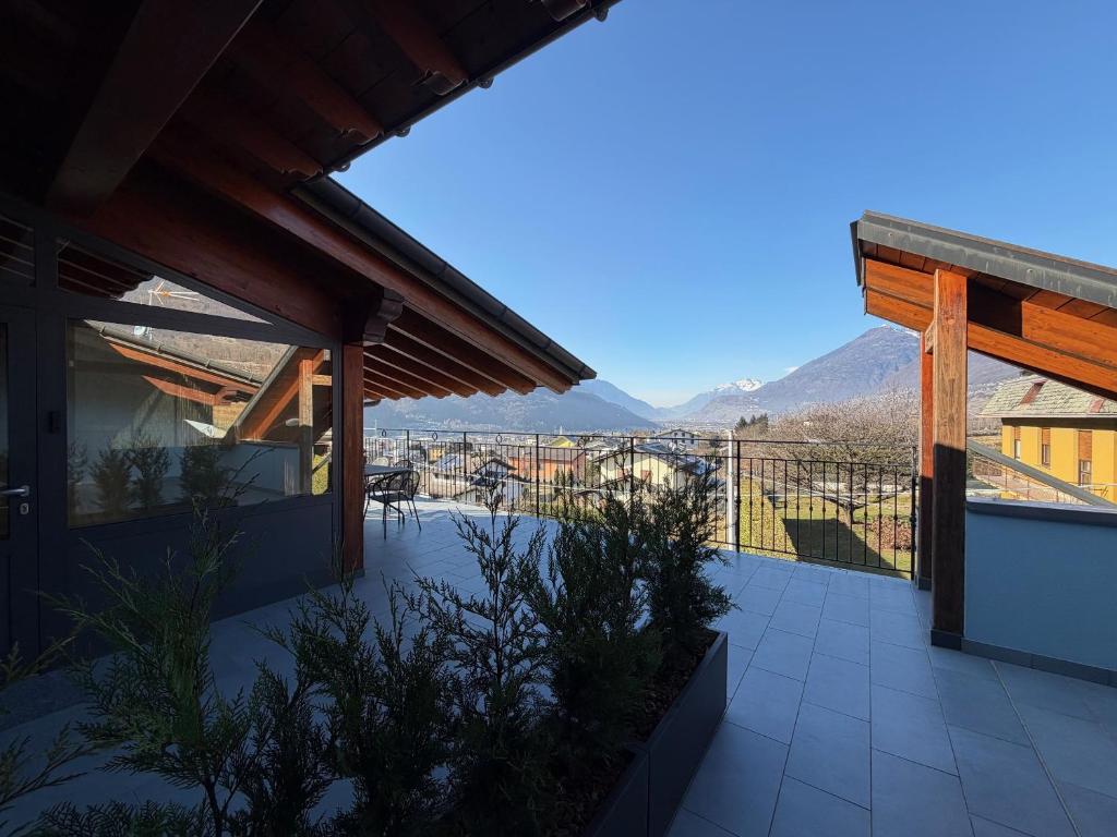 a house with a balcony with mountains in the background at Terrazza Retica in Piateda
