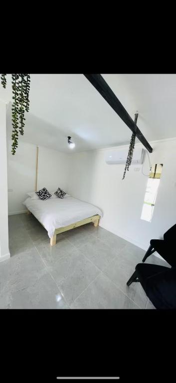 a bedroom with a bed in a white room at חמדת השקד in Mishmār Hāyardin