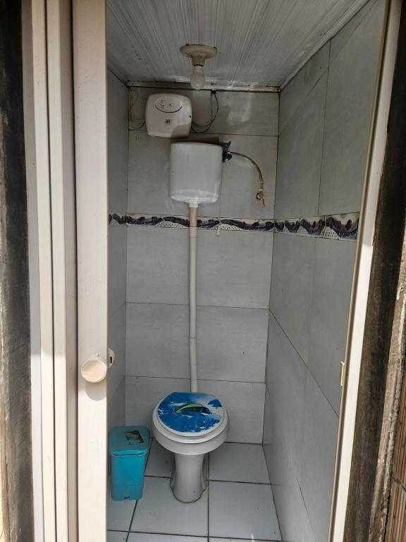 a small bathroom with a toilet with a blue seat at Casa para Carnaval in Olinda