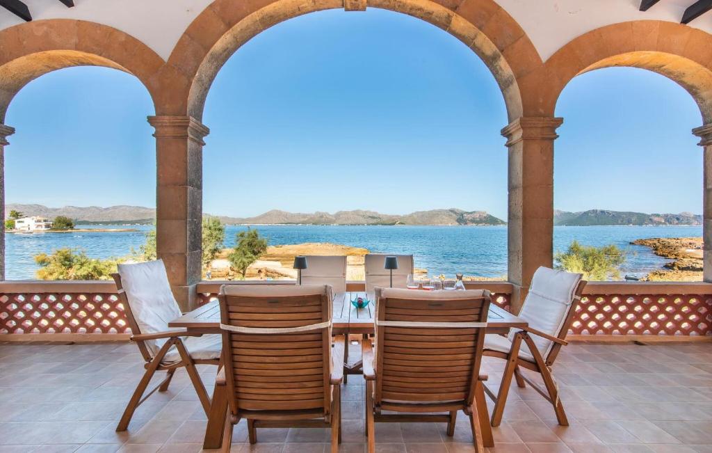 a table and chairs on a porch with a view of the water at Es Clot in Alcudia