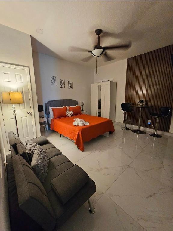 a bedroom with an orange bed and a couch at Romantic Suite in Tampa