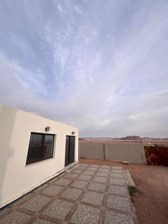 a white building with a window and a sky at Local experience in El Quweira