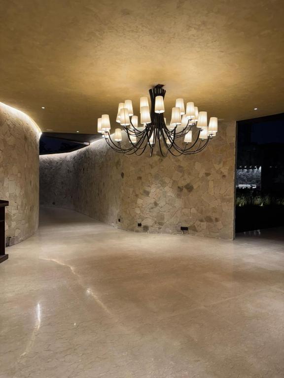 a chandelier in a room with a stone wall at Windsor House in Secunderabad