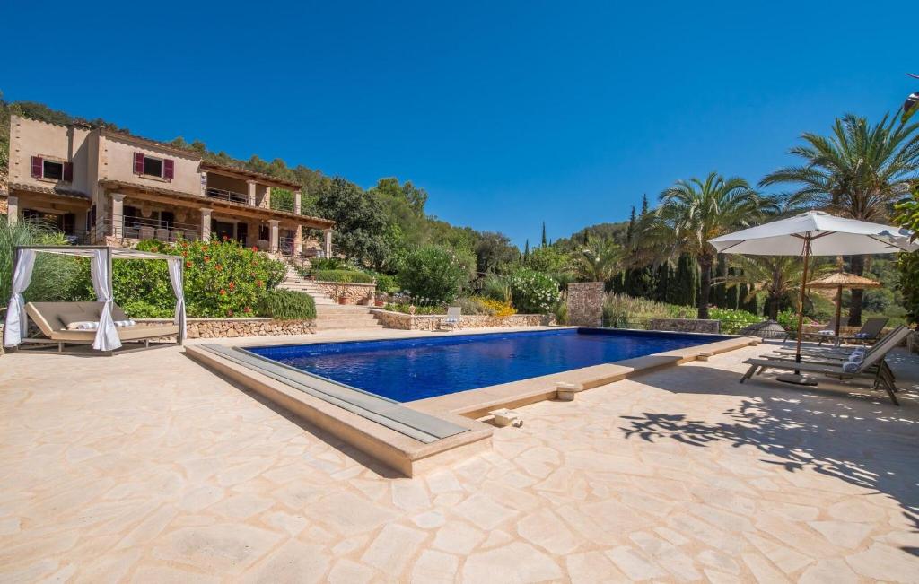 a villa with a swimming pool and an umbrella at Casa Amorena in Felanitx