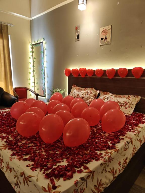 a bunch of red balloons on a bed at The Urban Perch in Greater Noida