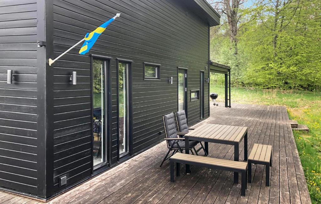 a house with a picnic table and chairs on a deck at Stunning Home In Örkelljunga With Sauna in Orkelljunga