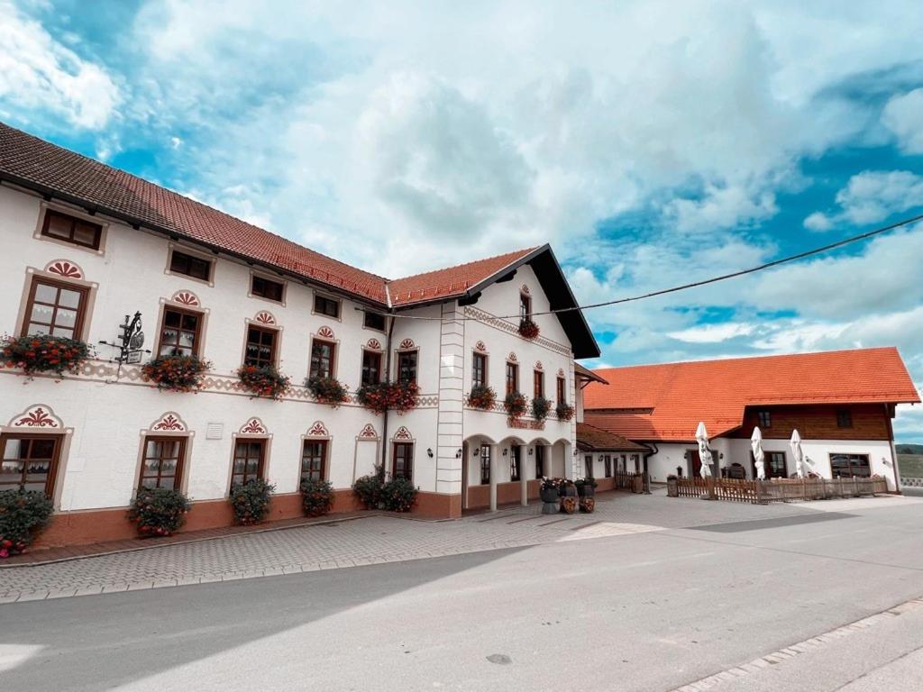 a large white building with a red roof at Gasthaus Stoiber in Buchbach