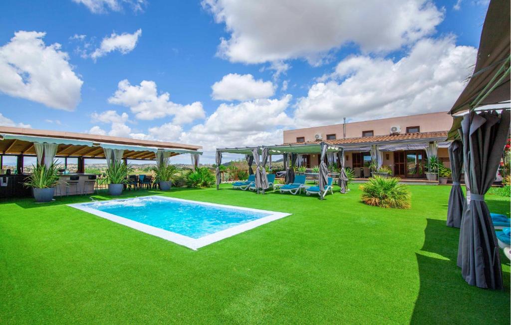a backyard with a swimming pool and green grass at Villa Son Gat Mallorca in Montuiri
