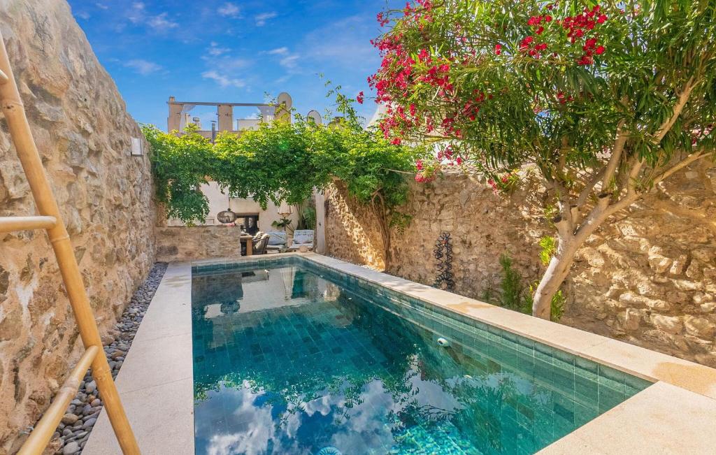 a swimming pool in a stone wall with a tree at Casa Max in Artá