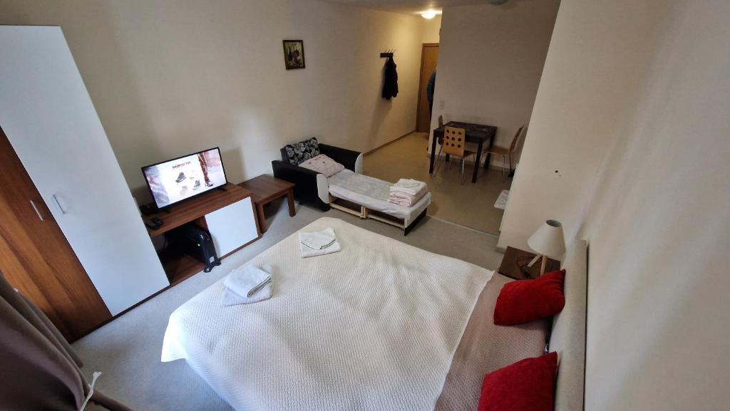 a living room with a white bed and a couch at Studio Kalina Green Life in Pamporovo