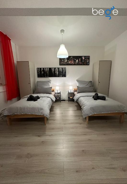 a room with three beds and a pendant light at BEGE APARTMENTS Next Level Sleep in Niederdorla