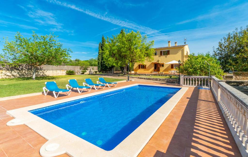 a pool with chairs and a house in the background at Sa Vileta in Sencelles