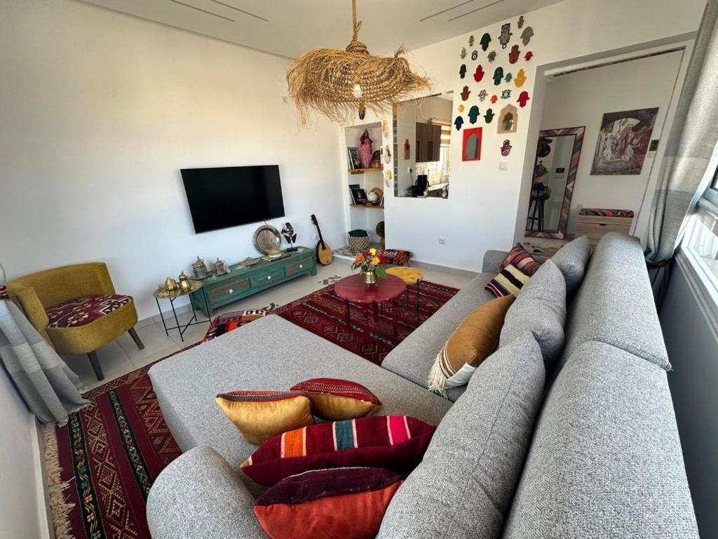 a living room with a couch and a tv at Telemly Douira el ALIA Alger in LʼAgha