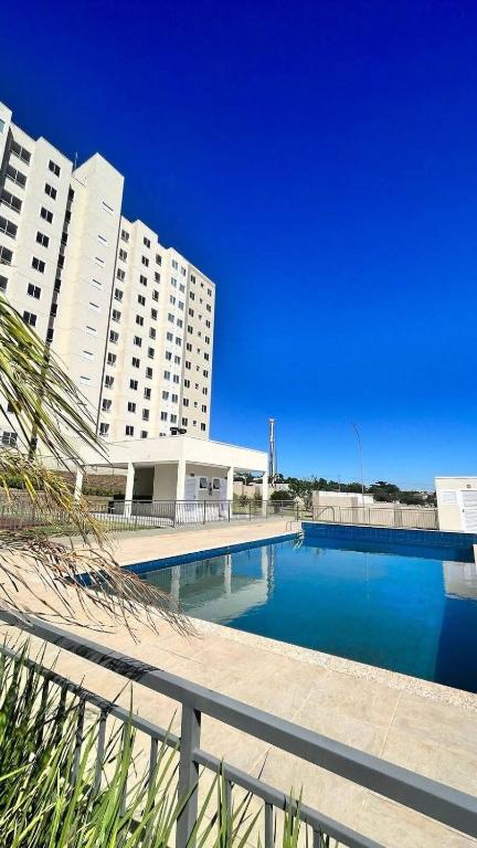 a large swimming pool in front of some buildings at Apartamento da Lagoa in Londrina