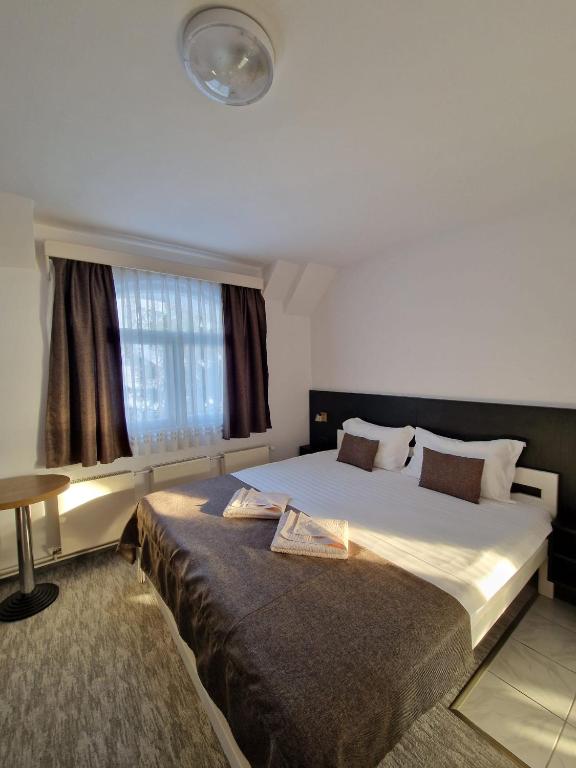 a bedroom with a large bed and a window at Erdős Panzió in Ditrău