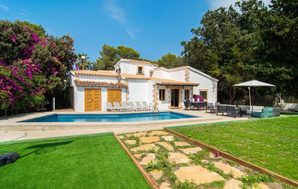 a villa with a swimming pool in a yard at El Tulipan Blanco in Alcudia