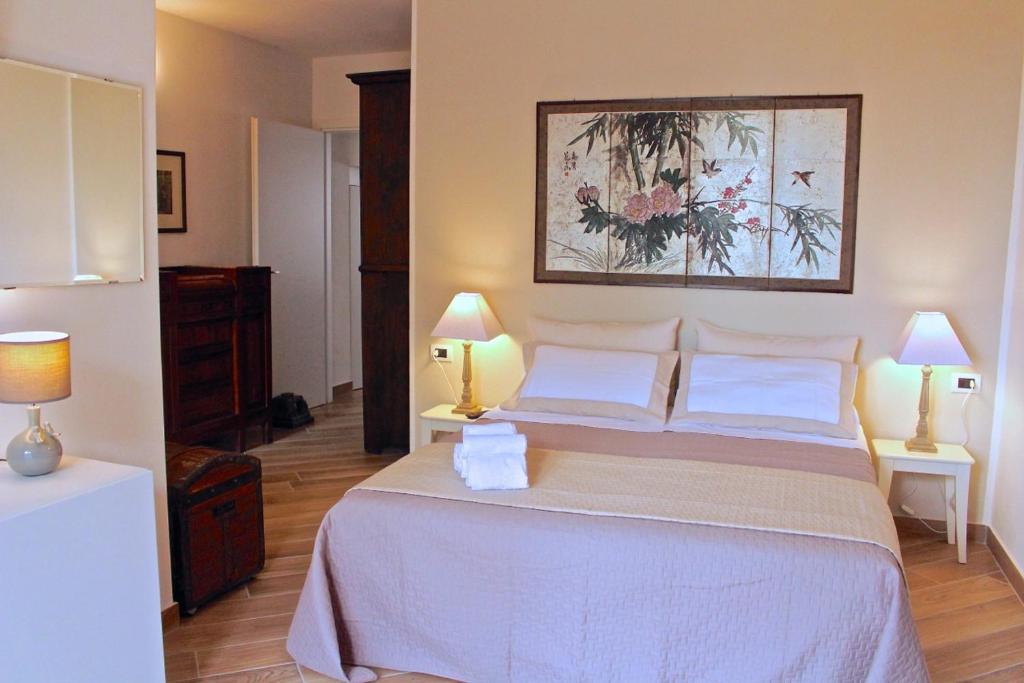een slaapkamer met een groot wit bed met 2 lampen bij La Piccola Corte di Malpensa in Vizzola Ticino