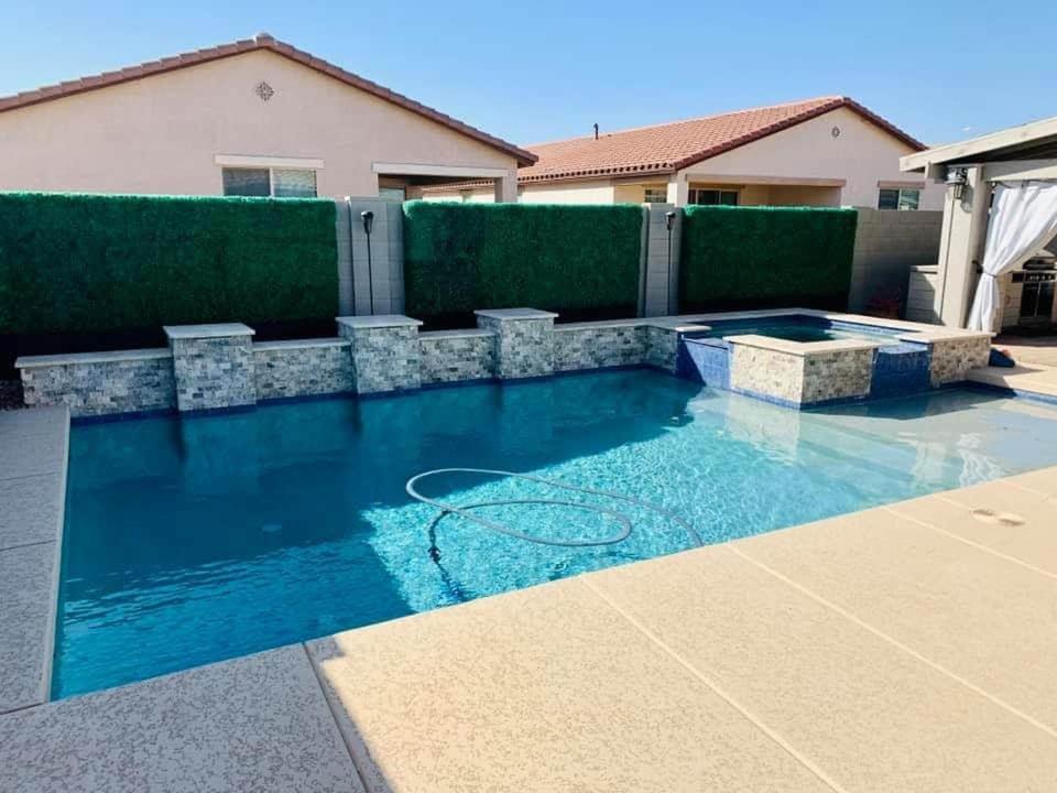 a swimming pool with blue water in a backyard at Homes by Abby LLC in Maricopa