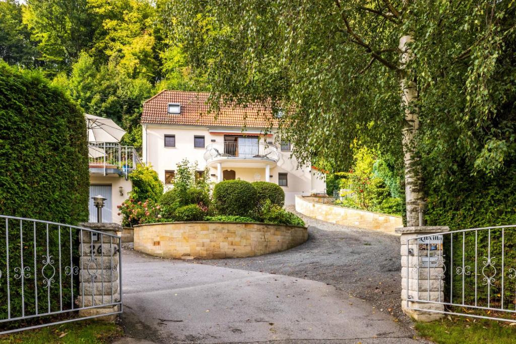 a house with a gate in front of a driveway at Elbvilla Pirna mit Sauna und Kamin mit privatem Zugang zur Elbe in Pirna
