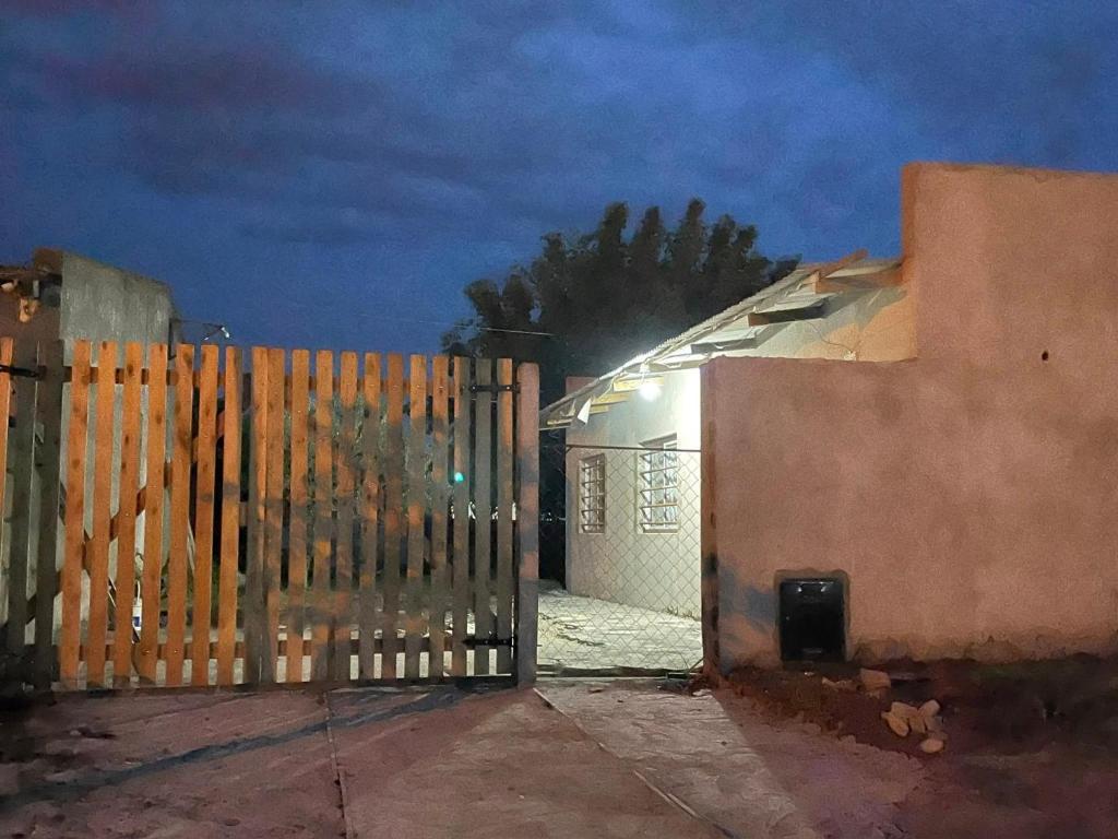 a gate to a house with a fence at night at Casa de Lore in Necochea