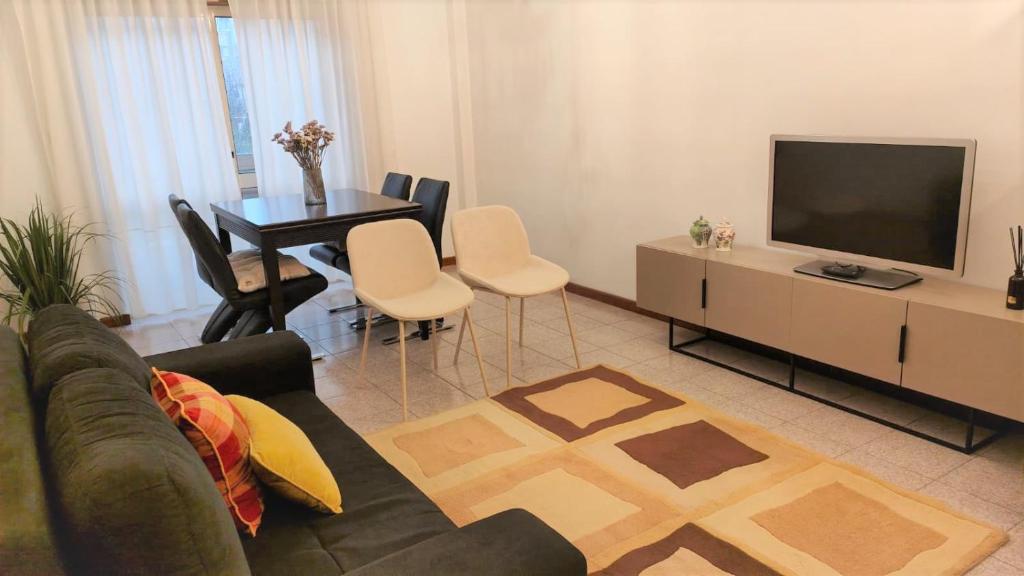 a living room with a couch and a tv and a table at LUCINDA`S HOUSE in Braga