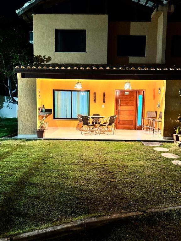 a house with a table and chairs in front of it at Casa Tororão - Arraial d'Ajuda in Porto Seguro