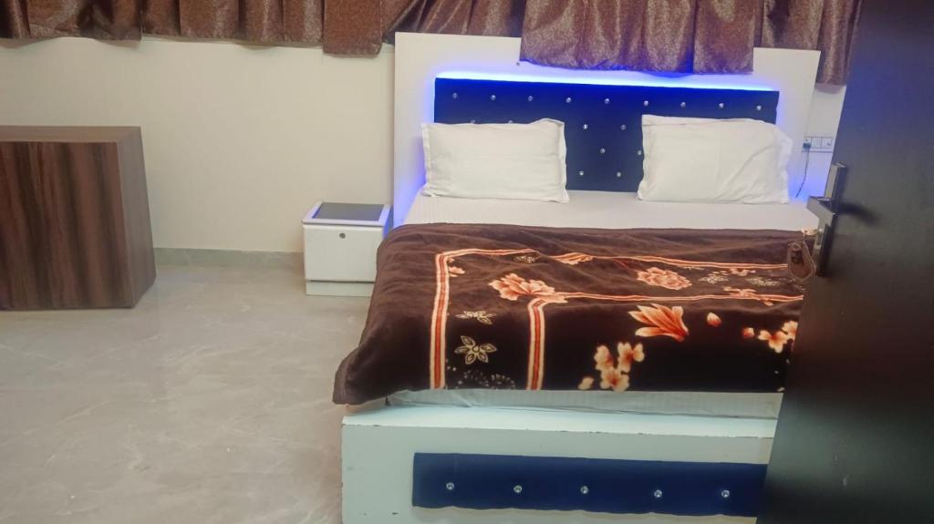 a bedroom with a bed with a blue headboard at Hotel New Mandpam in Orai