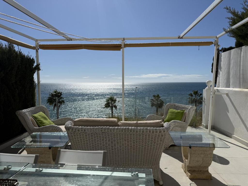 a patio with a table and chairs and a view of the ocean at Mediterranean Escape with Panoramic Sea Views in Benalmádena