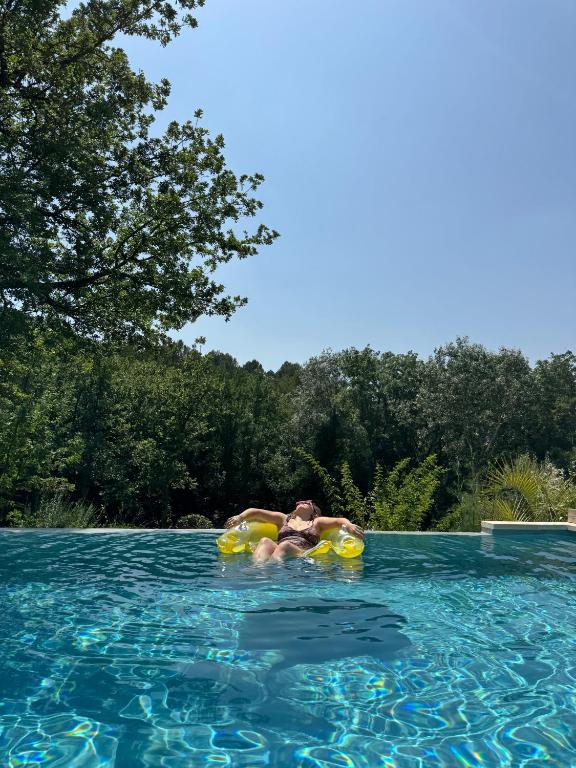 a person in a pool on an inner tube in the water at Villa Vauvert in Saignon