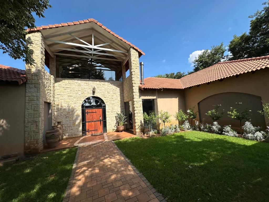 a house with a door and a grass yard at 20 at Meul in Potchefstroom