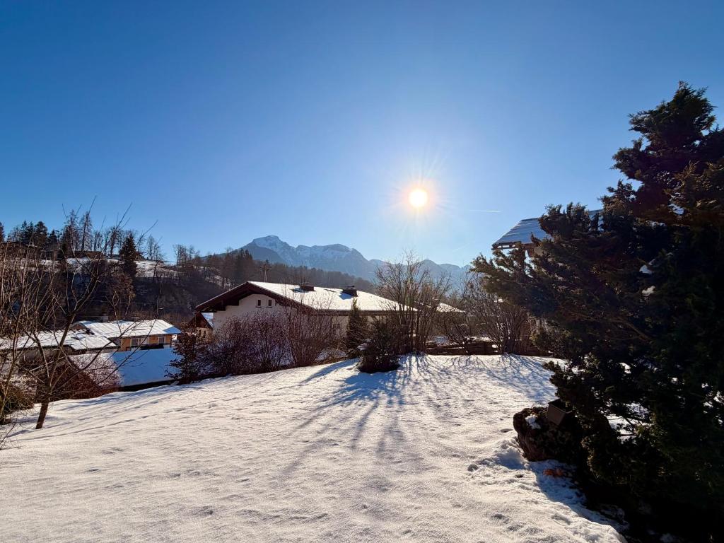 a snow covered yard with the sun in the sky at FeWo Reserl in Bischofswiesen