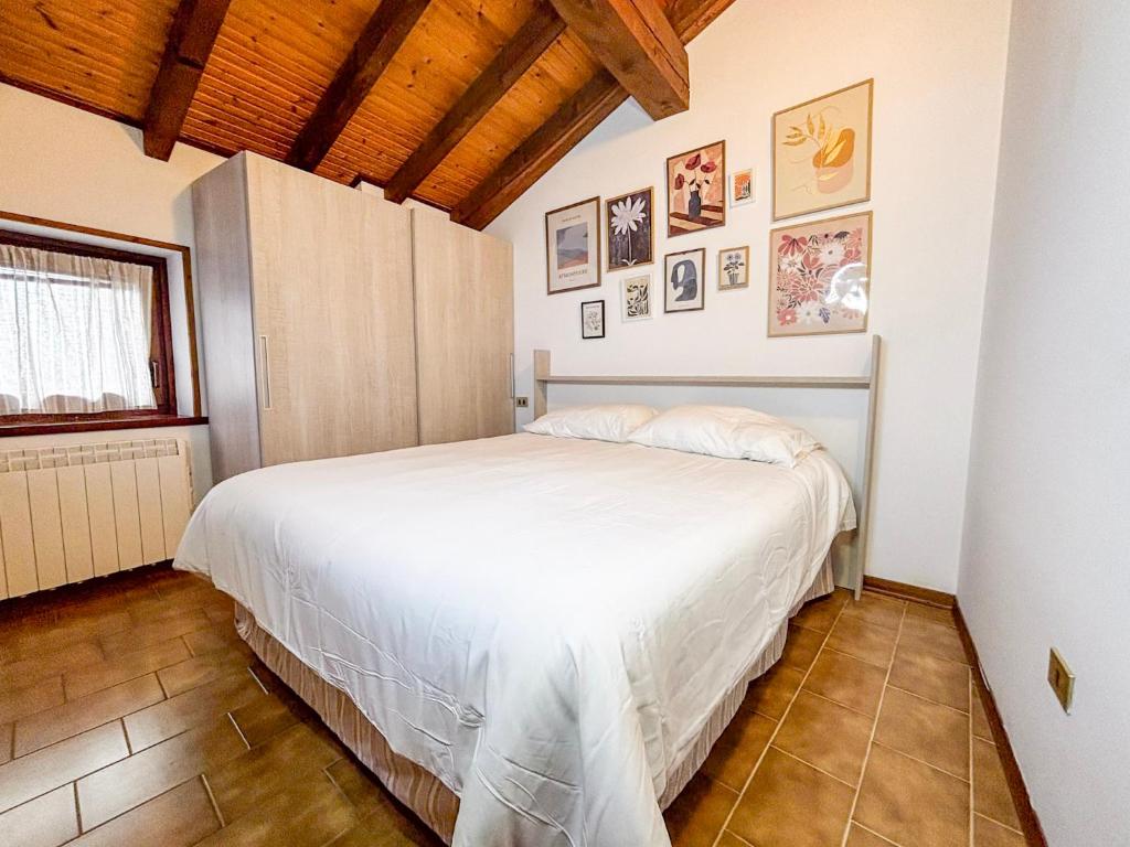 a bedroom with a white bed in a room at La Maison Pilly in Sondalo