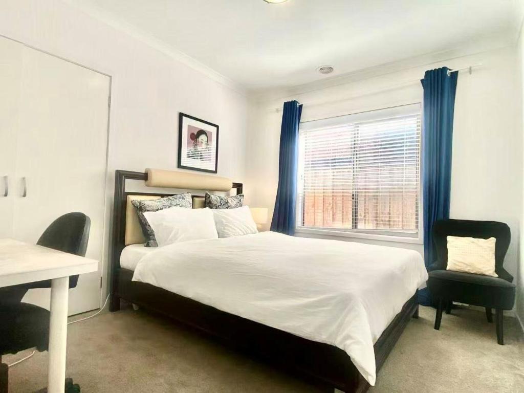a bedroom with a bed and a desk and a window at Point Cook Homestay House in Point Cook