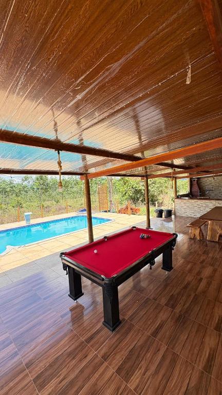 a red pool table in a pavilion with a swimming pool at Refúgio das Araras in Pirenópolis