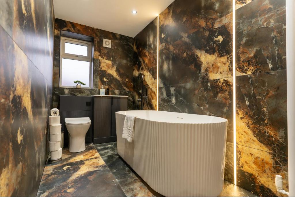 a bathroom with a bath tub and a toilet at Rose House in Boston