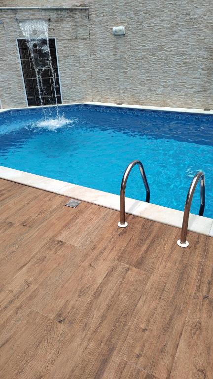 a swimming pool with a water fountain at Casa do Sol II in Peruíbe