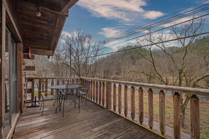 a porch with a table and chairs on a deck at Mountain View Cabins in Tellico Plains