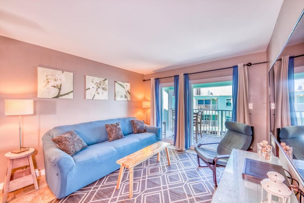 a living room with a blue couch and a table at Gulf Shores Barefoot Bliss in Gulf Shores
