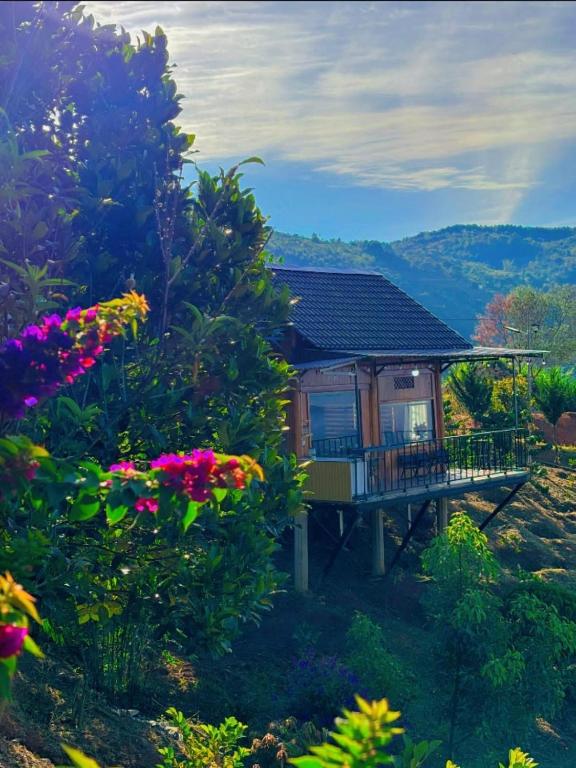 a house on a hill with flowers in the foreground at Căn gentle home in Da Lat