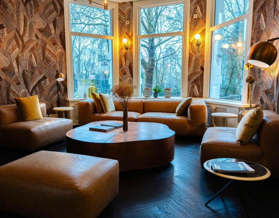 a living room with couches and a table at S&A Vondel Park Hotel in Amsterdam